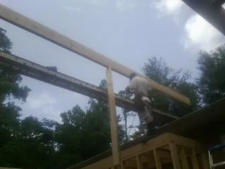 Carpenter setting a ridge beam over a new addition frame — Ice Dam Removal by Roofing Brothers in Garnet Valley