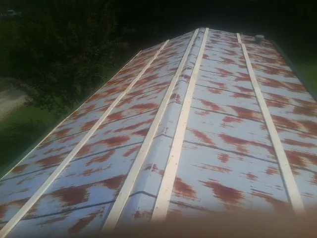 Rusted metal roof panels with new wood purlins before replacement — Storm Damage Roof Repair in Garnet Valley by Roofing Brothers