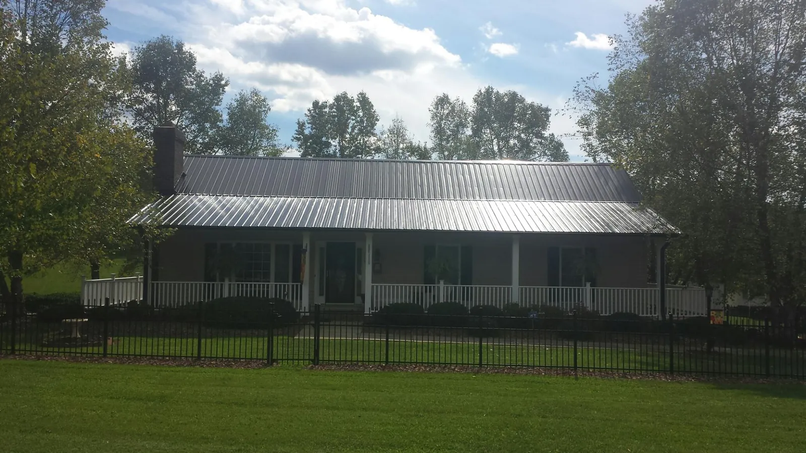 Gray metal roof on a brick ranch with a full width front porch — Gutter Guard Installation work by our crew in Garnet Valley