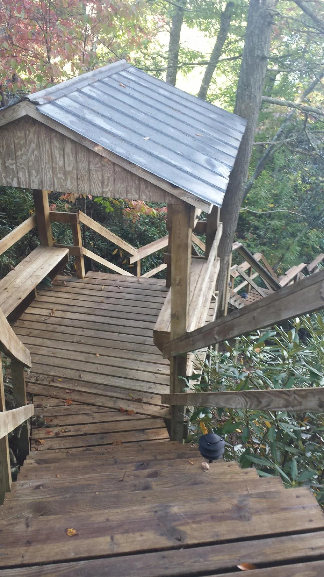 Metal roofed shelter over wooden steps on a wooded walkway — Skylight Repair & Installation work by our crew in Garnet Valley